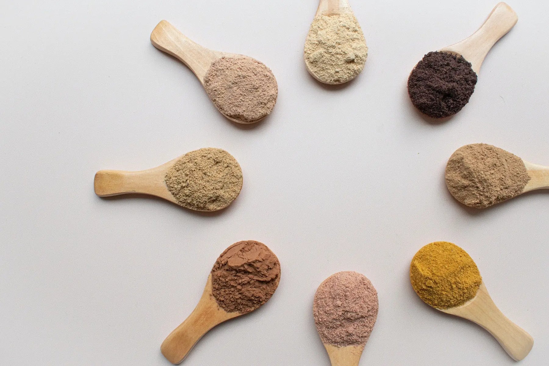 superfood powders on wooden spoons