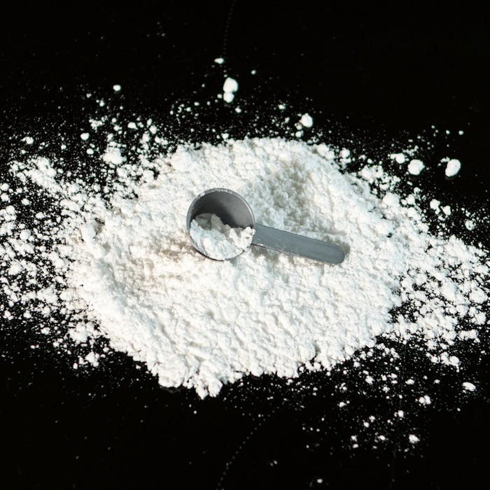 a scoop of powder next to a scoop of sugar