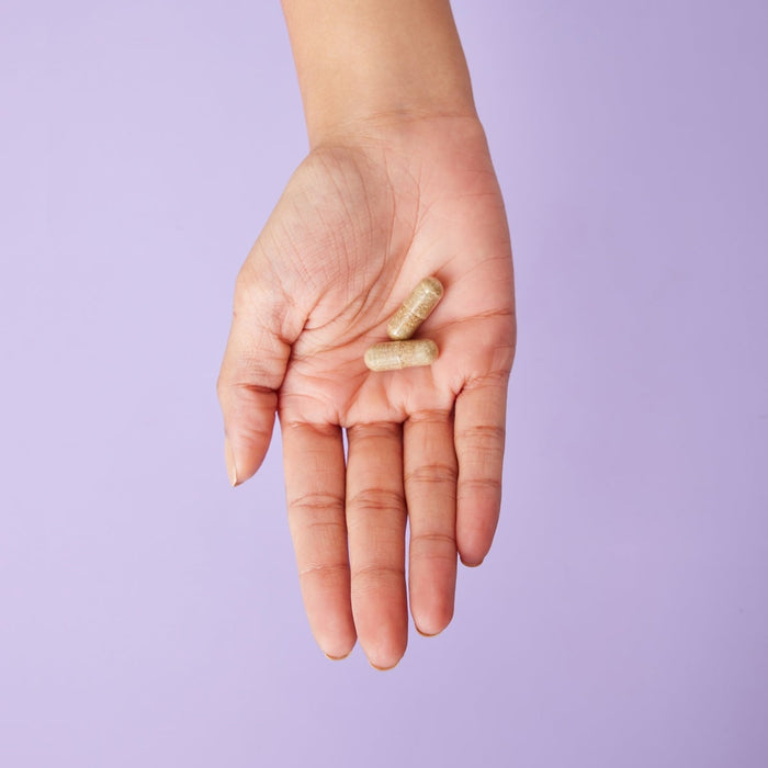 A person holding a pill in their hand
