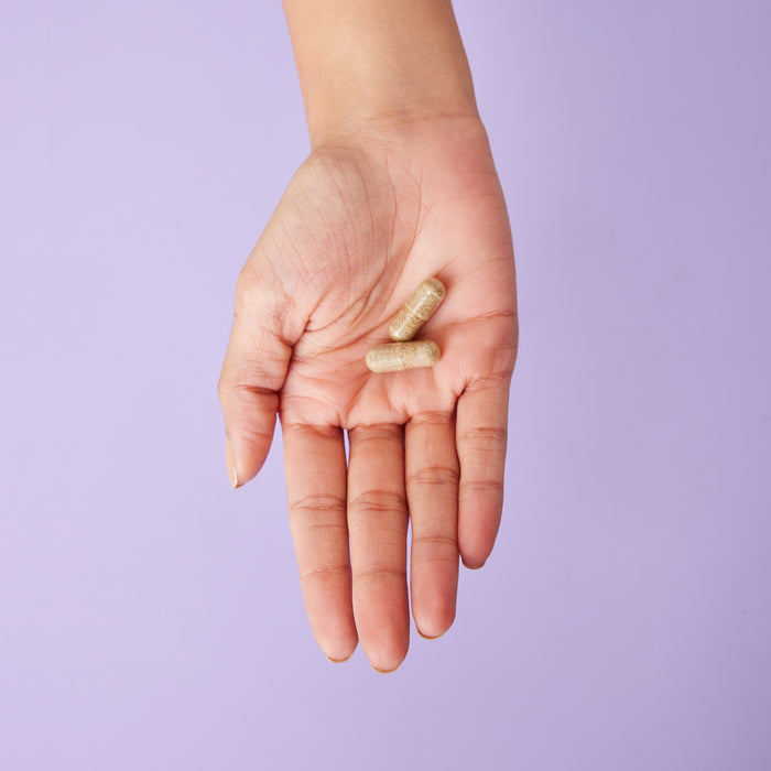 A person holding a pill in their hand